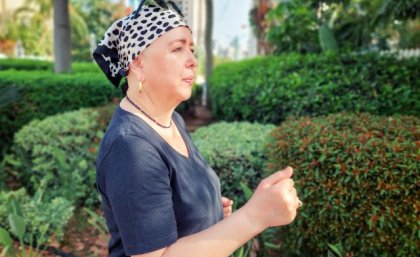 Woman wearing head scarf power walking through park. Adobe